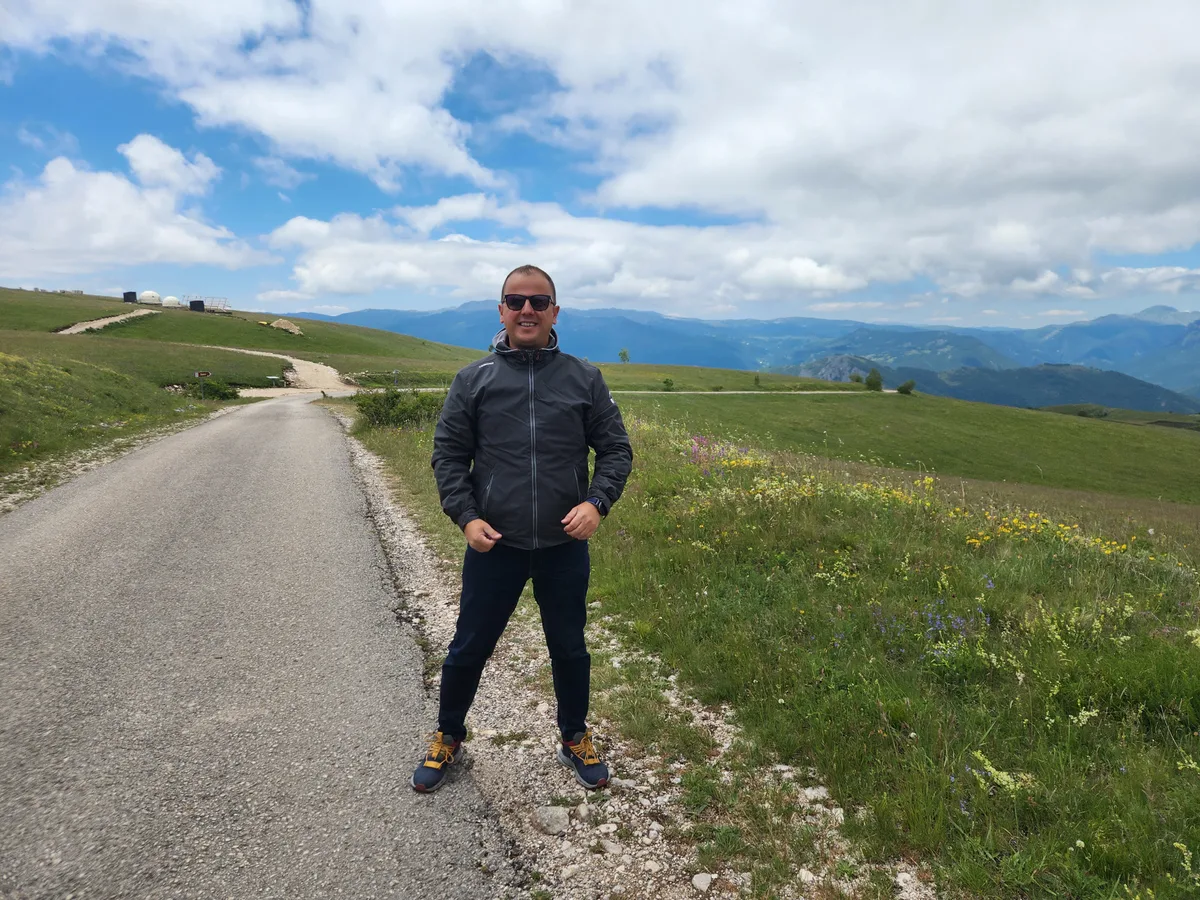 Besnik Pila standing on a mountain road in Albania